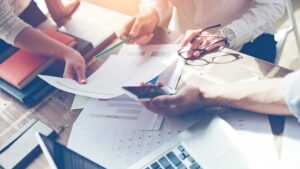 Business team brainstorming. Marketing plan researching. Paperwork on the table, laptop and mobile phone