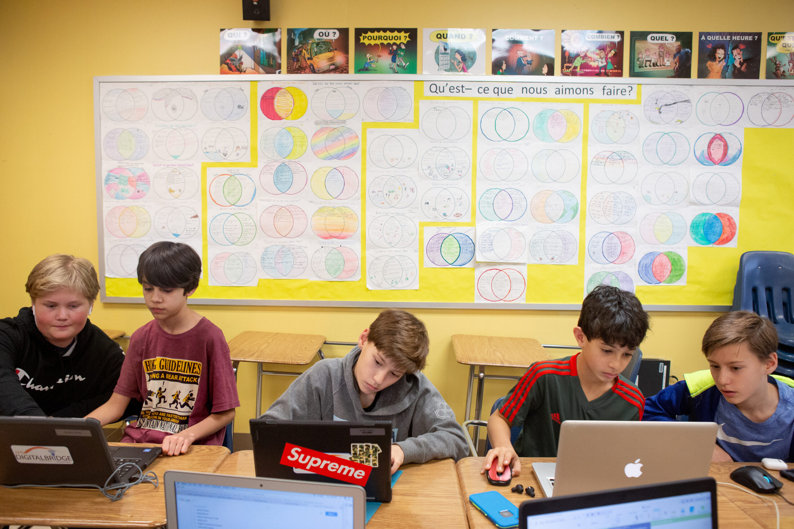 An image of five students in a 3-D printing club plan their next project.